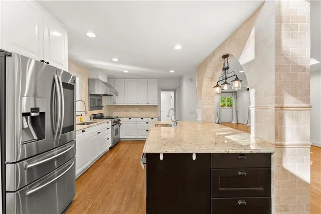 a kitchen with stainless steel appliances granite countertop a refrigerator and a sink