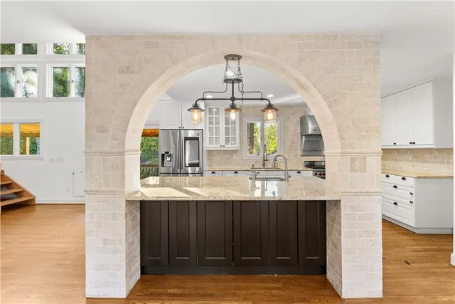 a kitchen with kitchen island a sink stainless steel appliances and cabinets