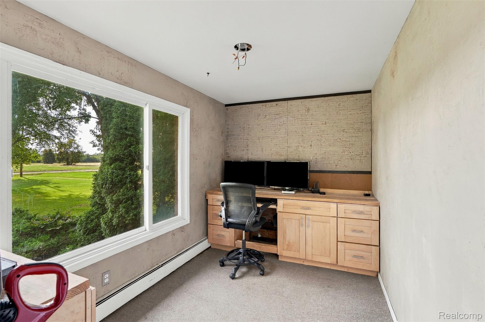 26516 Romine Road New Boston, MI 48164 - Photo 19 of 62 Expansive window with white trim, built-in light wood cabinetry and desk, textured wall finishes, and carpeted flooring
