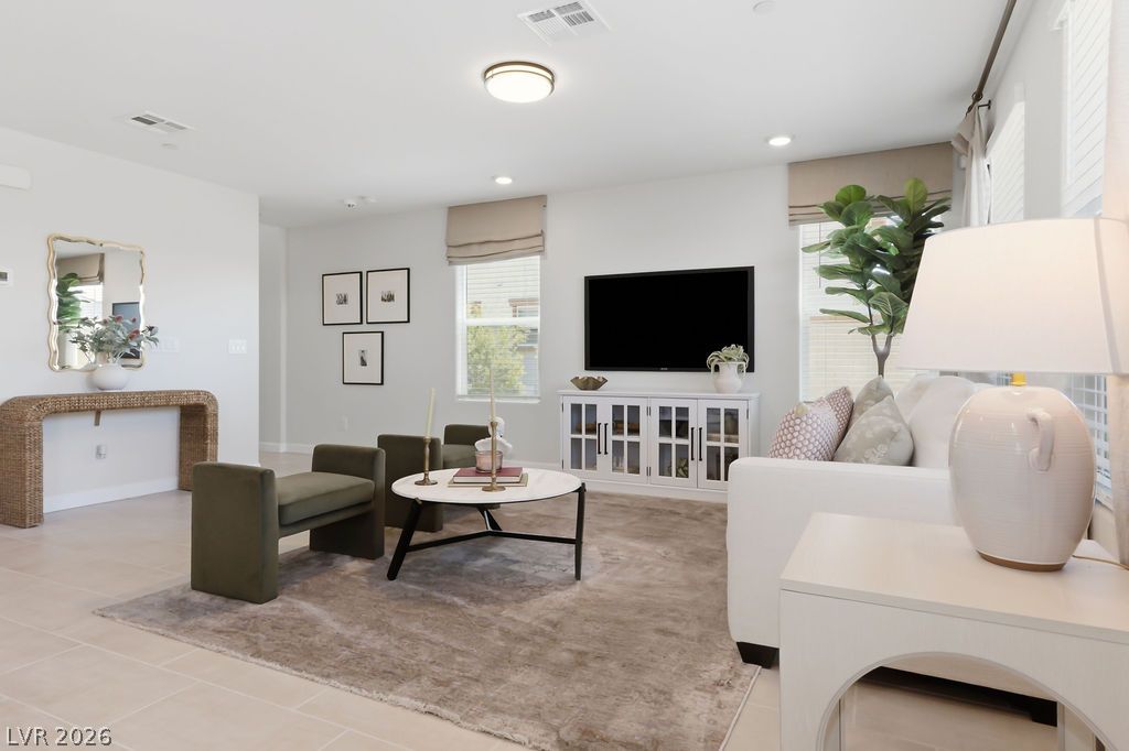 913 Cadence View Way Henderson, NV 89011 - Photo 13 of 46 The living area is illuminated by recessed lighting and a centered overhead light, offering a welcoming atmosphere for guests.