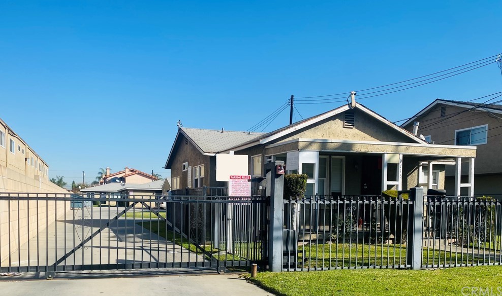 9713 Cedar Street Bellflower, CA 90706 - Photo 1 of 5 a view of a house with wooden fence