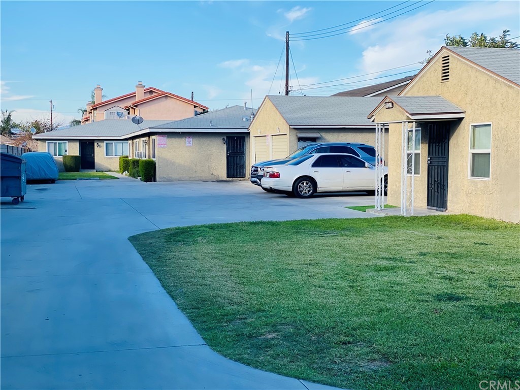 9713 Cedar Street Bellflower, CA 90706 - Photo 2 of 5 a front view of a house with a garden and parking