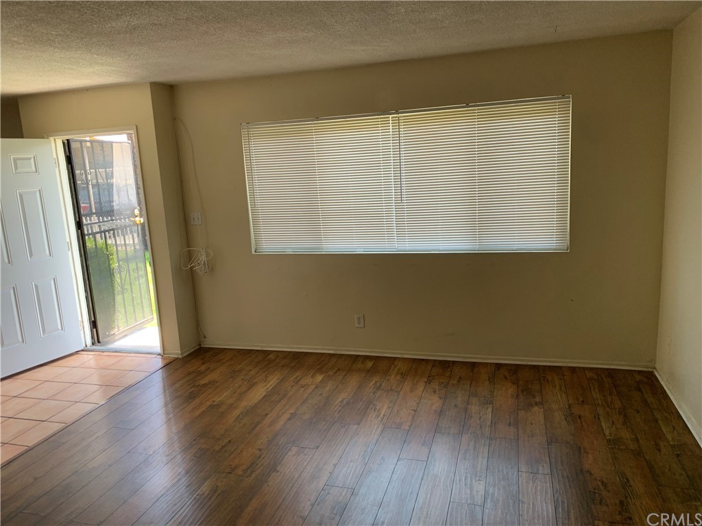 9713 Cedar Street Bellflower, CA 90706 - Photo 4 of 5 an empty room with wooden floor and a window