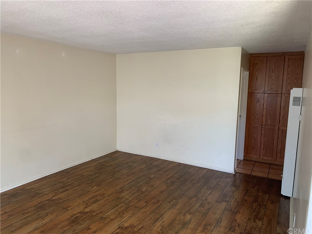 9713 Cedar Street Bellflower, CA 90706 - Photo 5 of 5 a view of an empty room with wooden floor and a window
