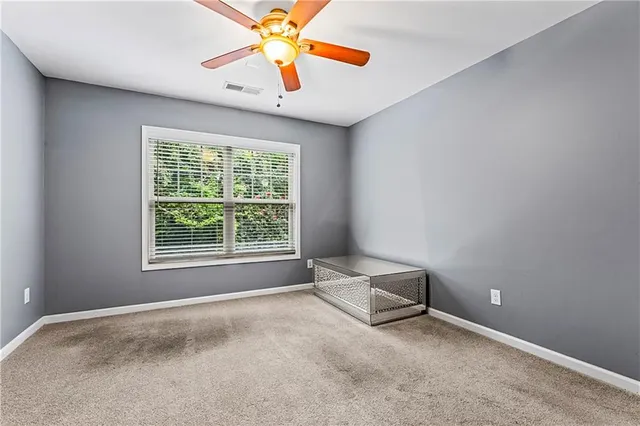 an empty room with closet and a chandelier fan