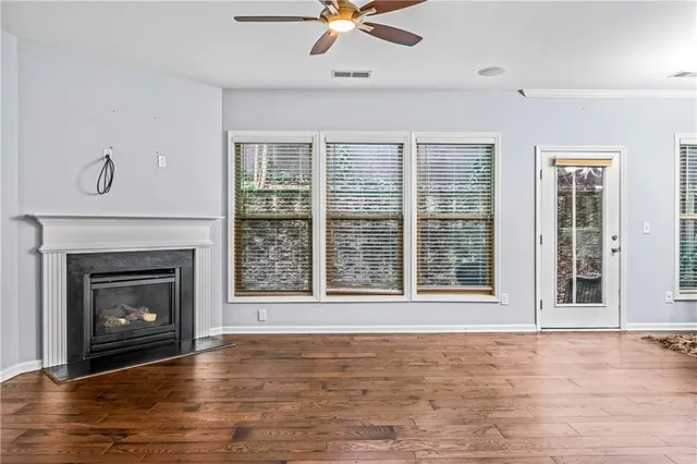 a view of an empty room with window and fire place