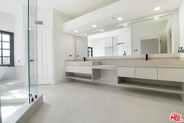 a large white kitchen with a white countertops and cabinets