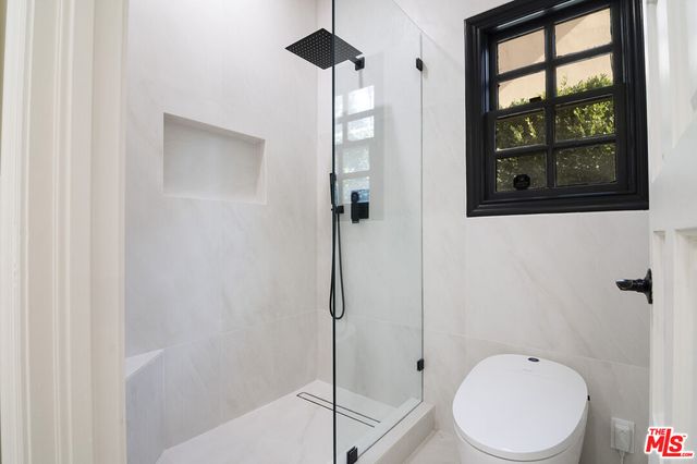 a bathroom with a toilet and a shower