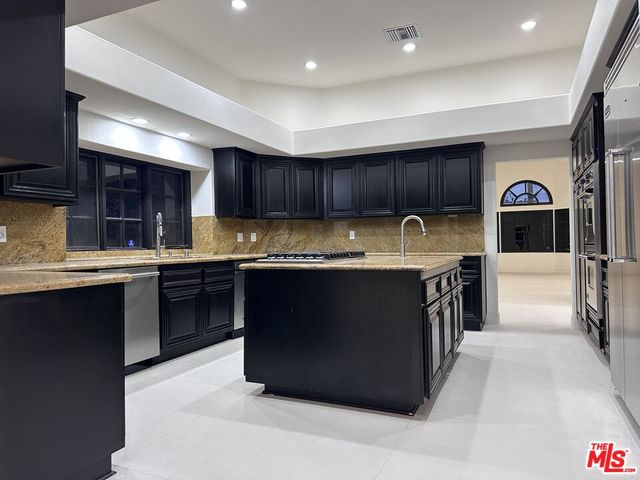 a kitchen with stainless steel appliances granite countertop a stove a sink and a refrigerator