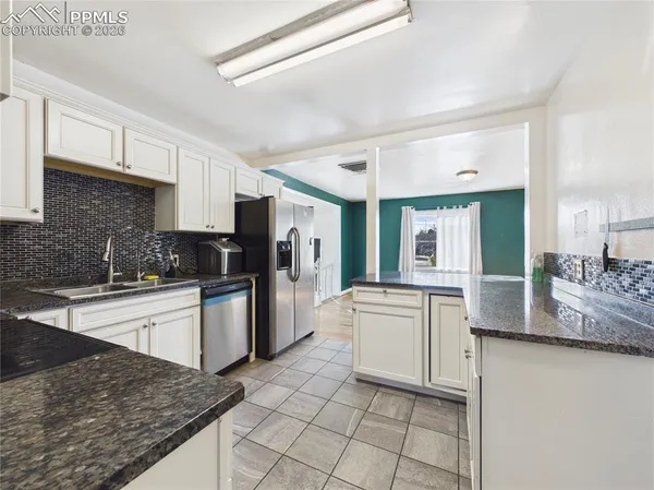 a kitchen with stainless steel appliances granite countertop a stove top oven a sink a counter space and cabinets