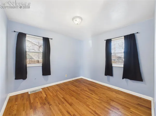 a view of a room with wooden floor and windows