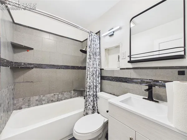 a bathroom with a sink a mirror toilet and bathtub