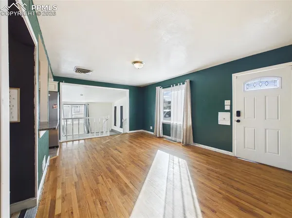 a view of a livingroom with wooden floor and staircase