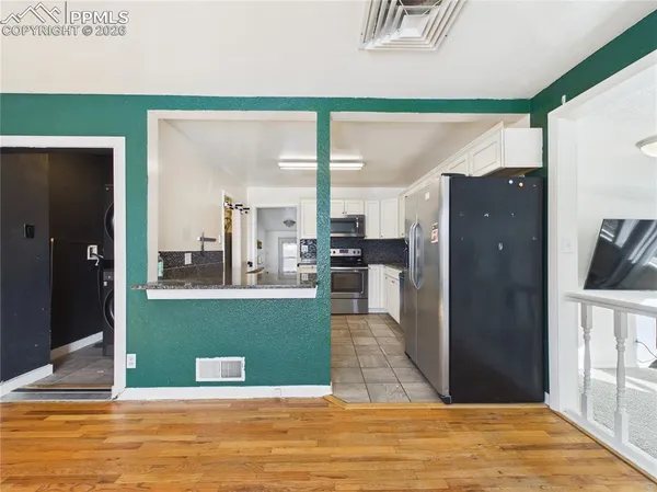 a view of kitchen with refrigerator and window