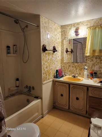 a bathroom with a tub sink and mirror