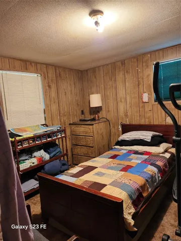 a bedroom with a bed and large windows