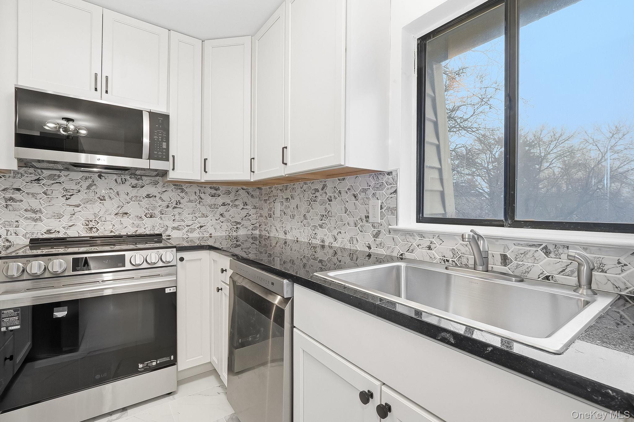 20 Pierces Road, Unit 36 Newburgh, NY 12550 - Photo 16 of 36 a kitchen with stainless steel appliances granite countertop a sink and a microwave