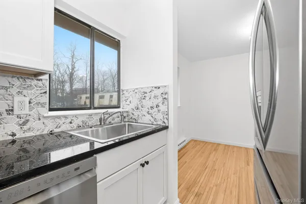 a sink with a granite countertop window and sink