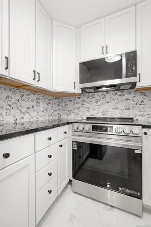 a stove top oven sitting inside of a kitchen