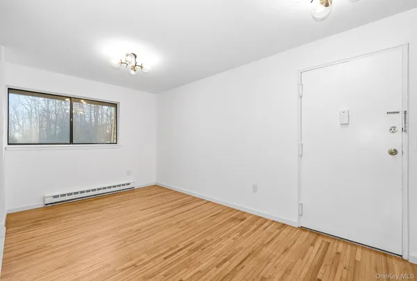 a view of empty room with wooden floor