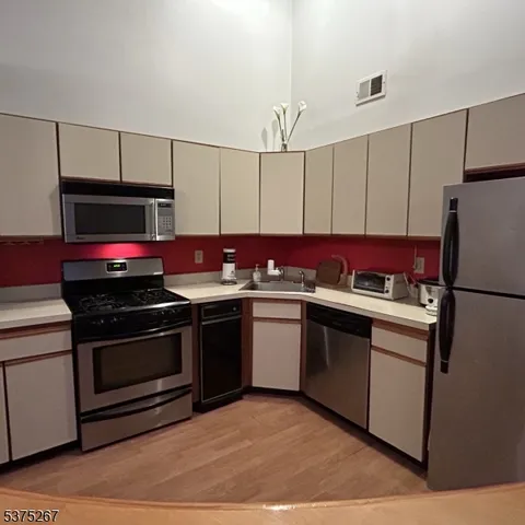 a kitchen with stainless steel appliances a stove a microwave and a refrigerator