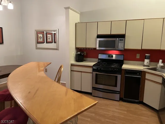 a kitchen with stainless steel appliances a stove a microwave a sink and cabinets