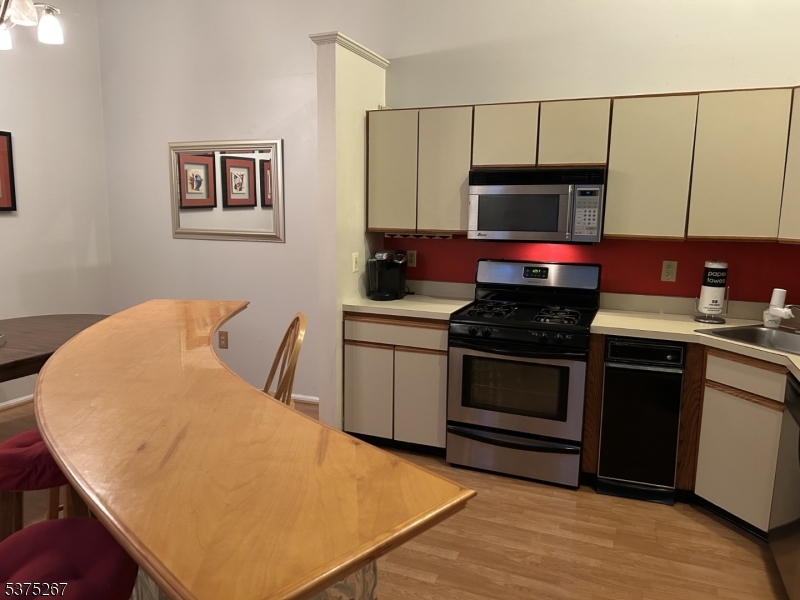 2512 Lindsley Road Bridgewater, NJ 08807 - Photo 8 of 39 a kitchen with stainless steel appliances a stove a microwave a sink and cabinets