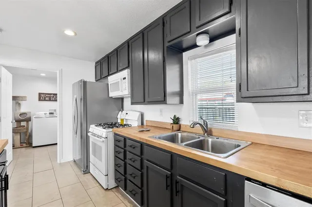 a kitchen that has a sink a refrigerator and cabinets
