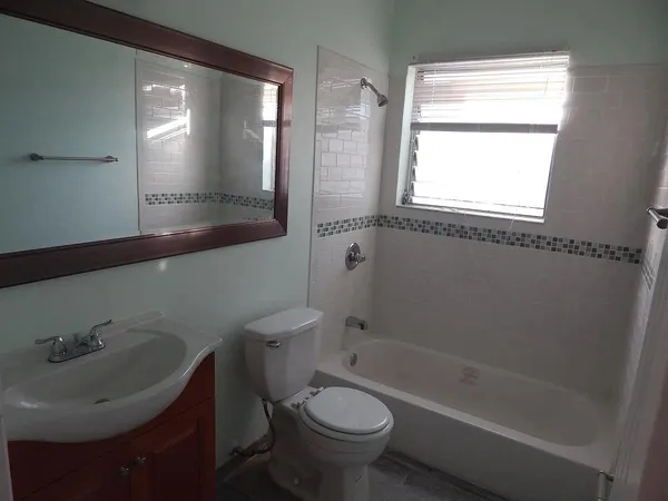 a bath room with a toilet a sink and a bath tub