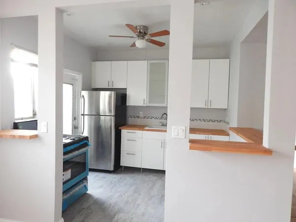 a kitchen with white cabinets and stainless steel appliances