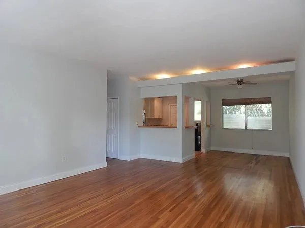 a view of empty room with wooden floor