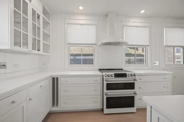 a kitchen with white cabinets and a stove top oven