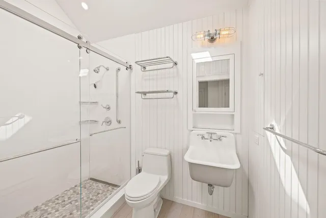 a bathroom with a sink a toilet and shower