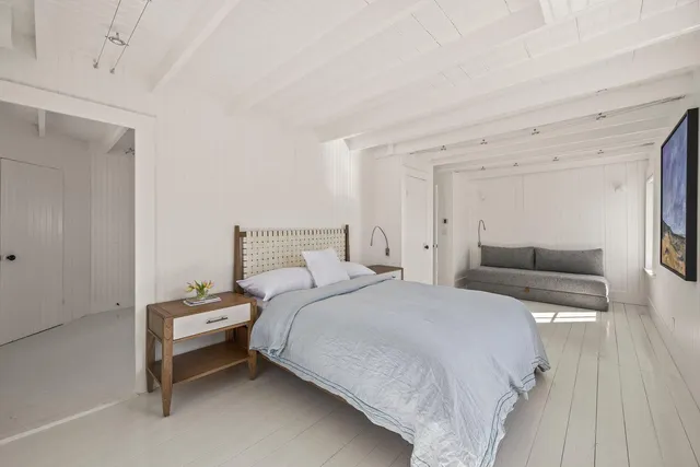 a bedroom with bed and a wooden floor