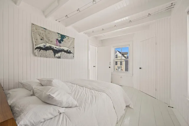 a bedroom with a bed and a painting on the wall