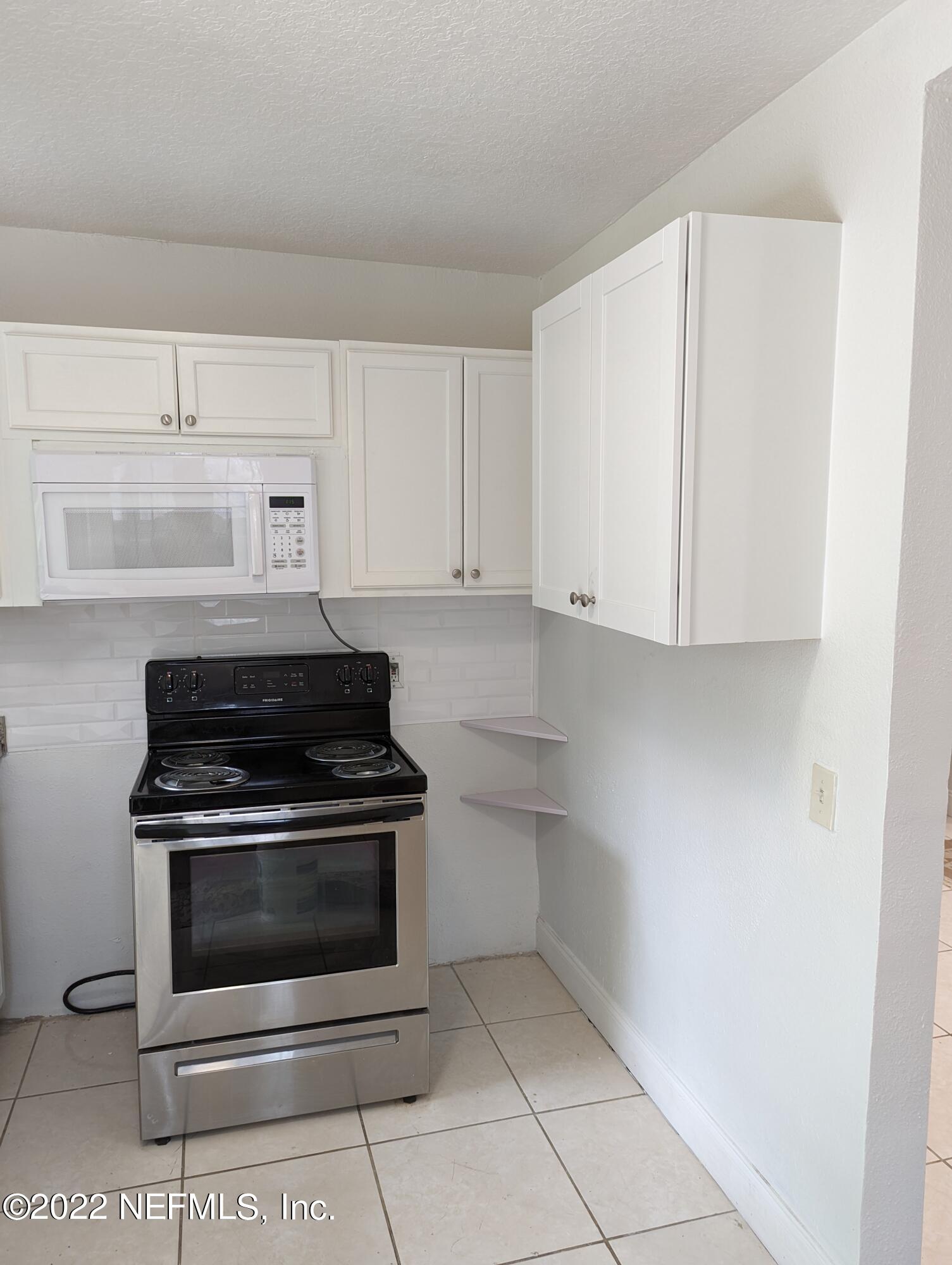 2171 Morehouse Road Jacksonville, FL 32209 - Photo 16 of 17 a kitchen with white cabinets and appliances