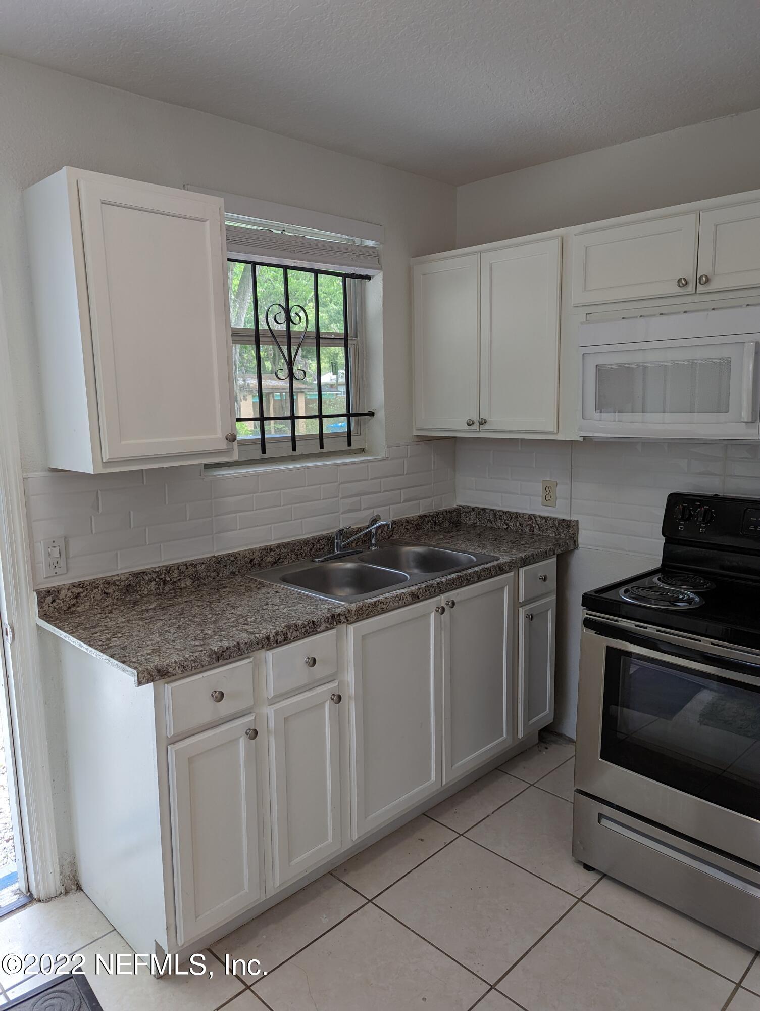 2171 Morehouse Road Jacksonville, FL 32209 - Photo 17 of 17 a kitchen with granite countertop white cabinets and white appliances