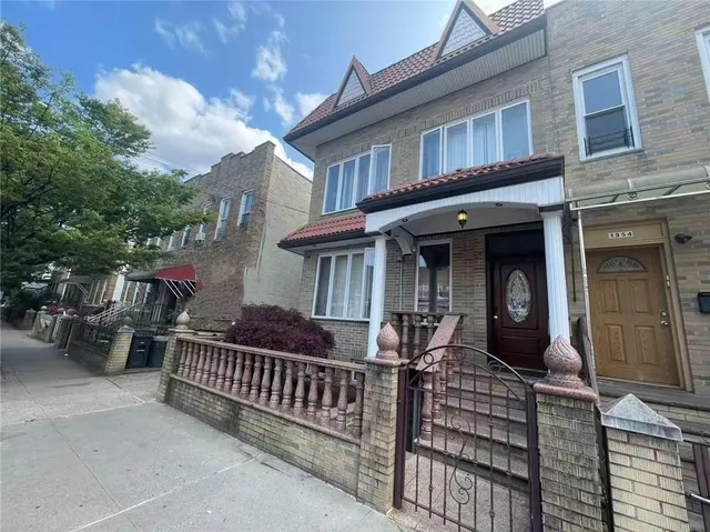 a view of a house with large windows and a small yard