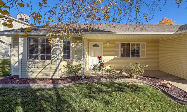 a view of a house with potted plants and a table and chairs