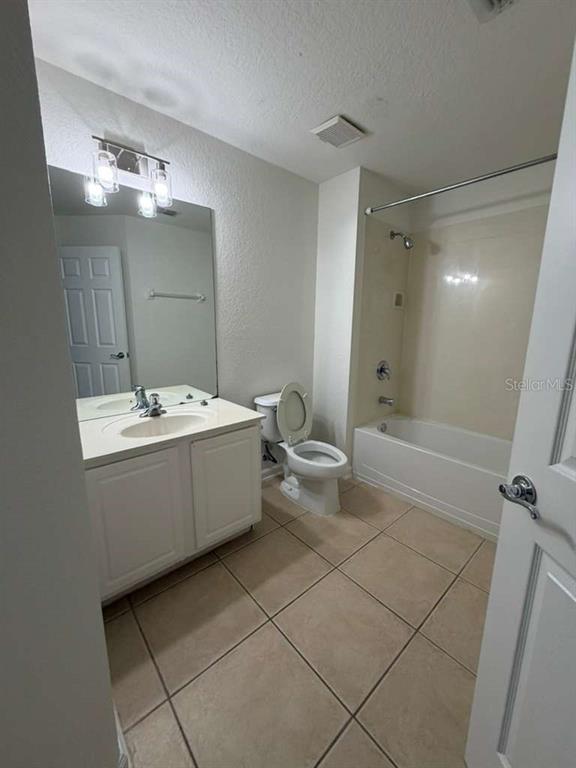 2838 Villafuerte Point, Unit 104 Orlando, FL 32835 - Photo 11 of 17 a bathroom with a double vanity sink mirror and toilet