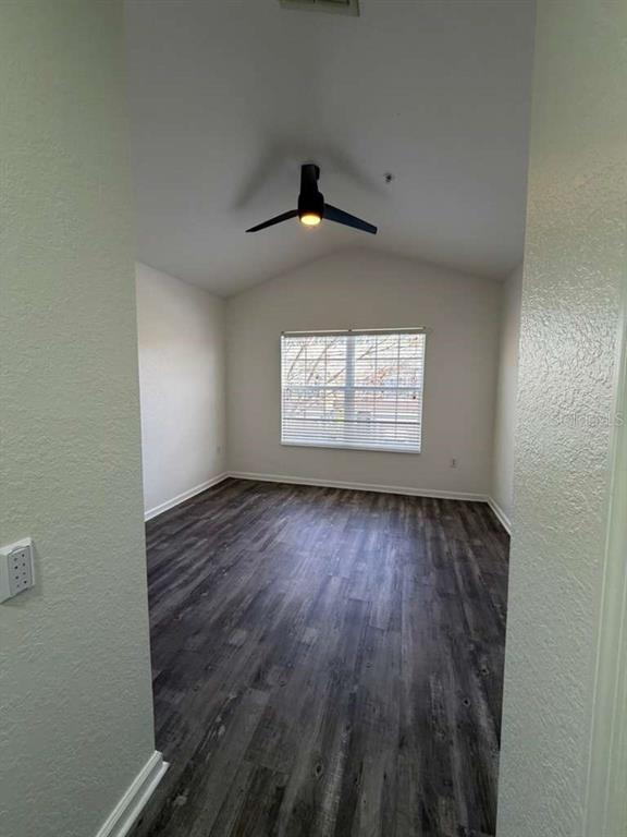 2838 Villafuerte Point, Unit 104 Orlando, FL 32835 - Photo 14 of 17 an empty room with wooden floor and windows