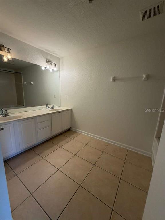 2838 Villafuerte Point, Unit 104 Orlando, FL 32835 - Photo 15 of 17 a bathroom with a sink a toilet and mirror