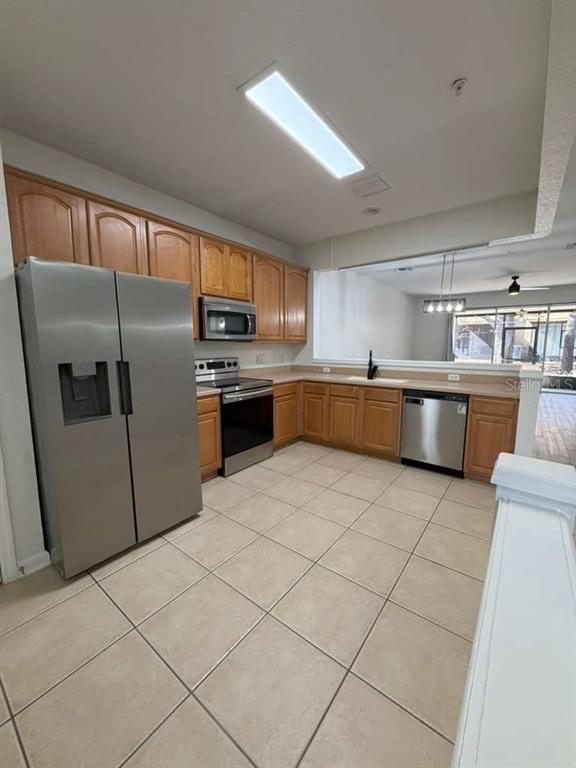 2838 Villafuerte Point, Unit 104 Orlando, FL 32835 - Photo 4 of 17 a kitchen with stainless steel appliances a refrigerator sink and cabinets