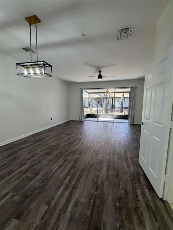 2838 Villafuerte Point, Unit 104 Orlando, FL 32835 - Photo 5 of 17 a view of an empty room with wooden floor and a window