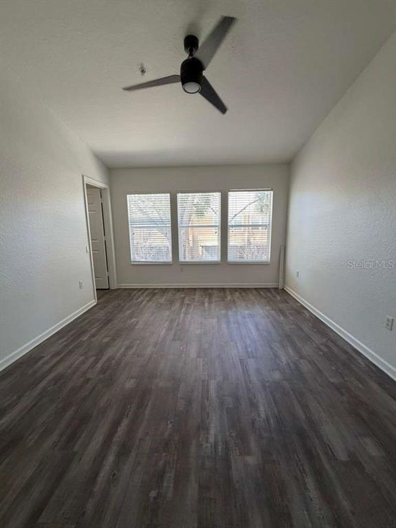 2838 Villafuerte Point, Unit 104 Orlando, FL 32835 - Photo 9 of 17 an empty room with wooden floor and windows