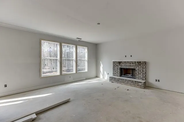 a view of an empty room with a window and a fireplace