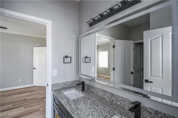 a bathroom with a granite countertop sink and a mirror