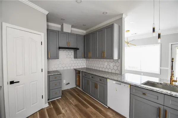 a kitchen with granite countertop a sink stainless steel appliances and cabinets