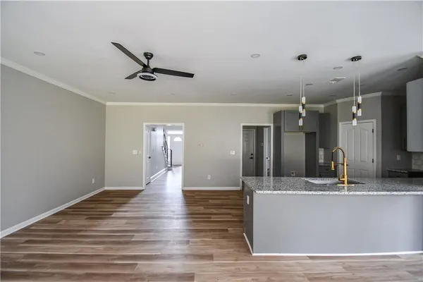 a view of a room with wooden floor a ceiling fan and windows
