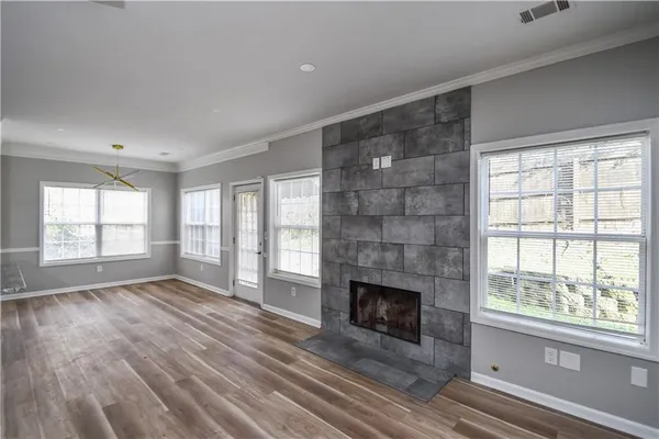 a view of empty room with wooden floor and fireplace